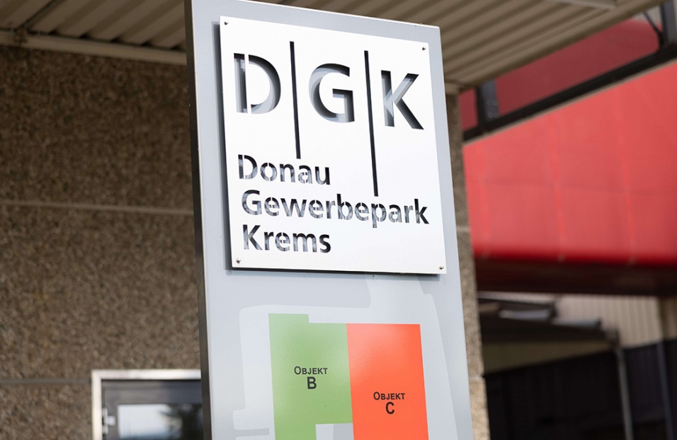 Tafel beim Haupteingang des Gebäudes mit eingestanztem DGK-Logo